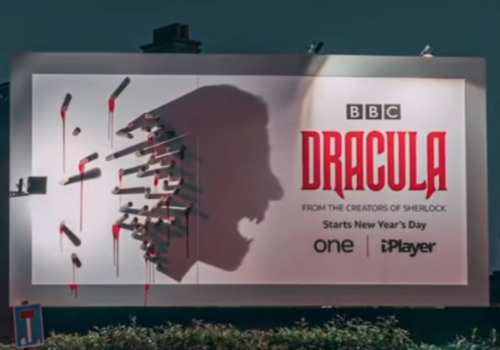 BBC Dracula billboard showing stakes by day that cast a Dracula face shadow at night